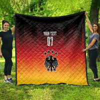 Germany football quilt blanket held on grass; black, red, yellow with eagle and three stars