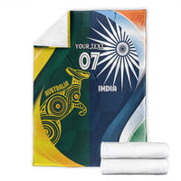 Cricket blanket folded stack, half Australia yellow-green and half India navy, 'YOUR TEXT'.