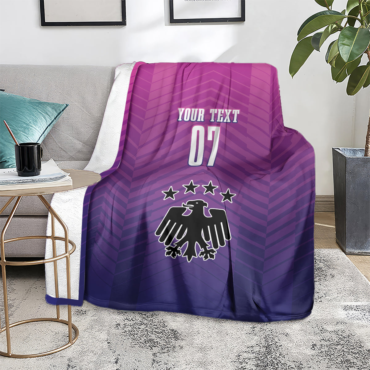 Germany football blanket on chair, "YOUR TEXT 07" and crest in purple and pink.
