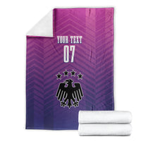 Germany football blanket folded, "YOUR TEXT 07" crest design with two rolled white towels.