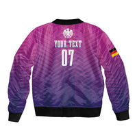 Unisex purple football bomber jacket with chevron pattern, back graphic, and elastic hem