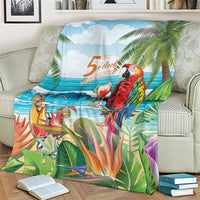 Tropical throw blanket over seating, featuring red parrot, palm leaves, and ocean horizon print