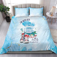 Blue bedding set on bed with “I'm with her” quote and building-and-sneaker artwork