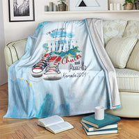 Light blue blanket draped over couch with 'I'm with her' text and red sneakers illustration
