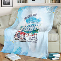 Light blue blanket with 'I'm with her' slogan, building scene, and red-and-gray sneakers