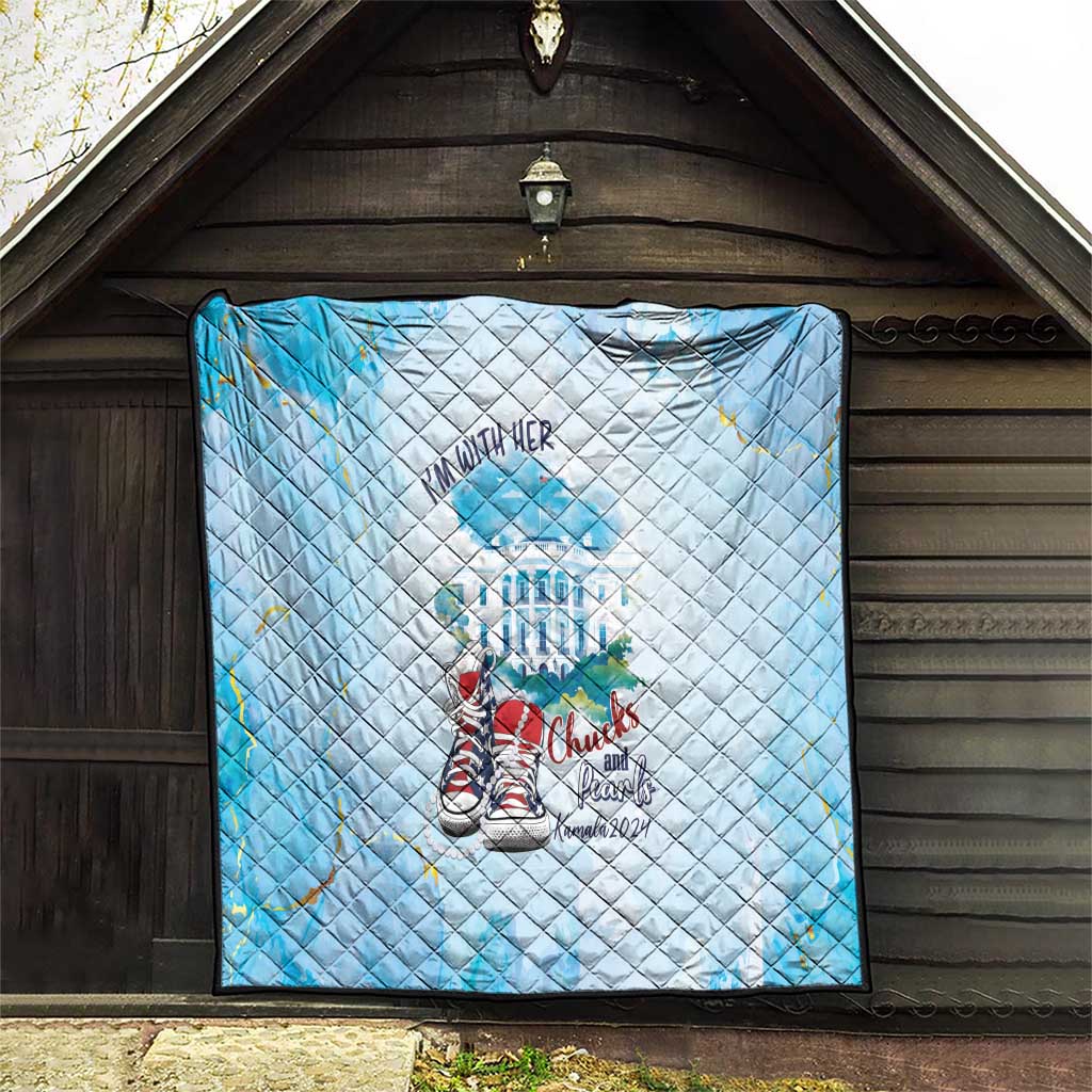 Light blue quilt hung on wall, diamond quilting with “I’m With Her” and sneaker graphic