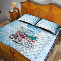 Light blue quilt bed set with matching pillows, sneaker and logo print across bedspread