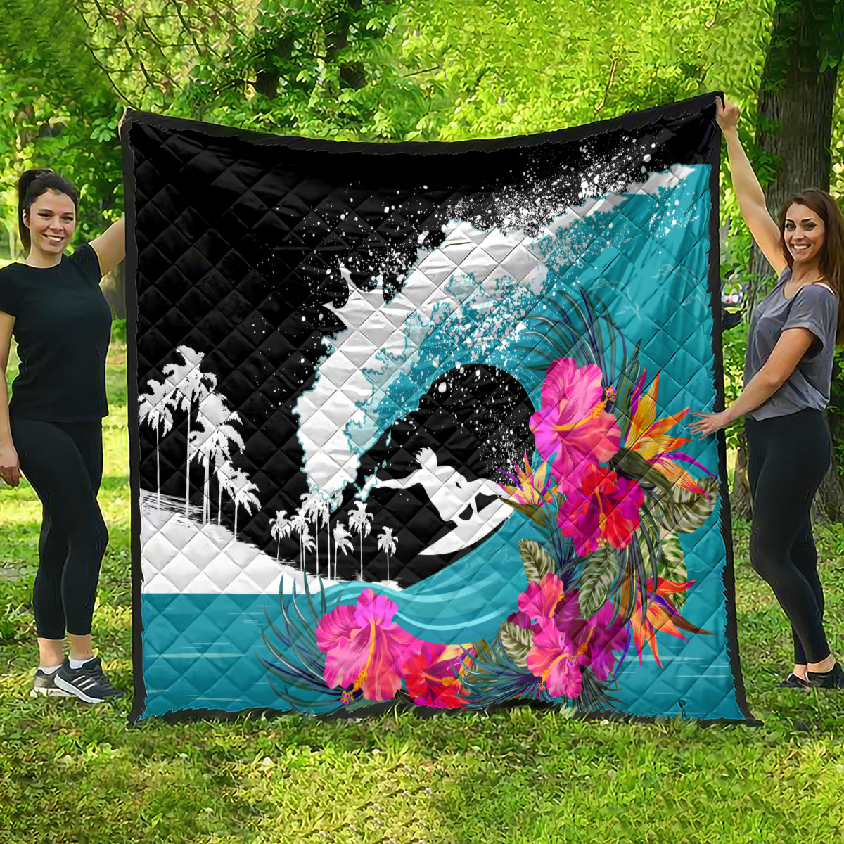 Large black, white, and teal quilt with surfing graphic, pink tropical flowers, quilted texture.