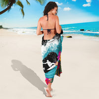 Tropical sarong draped on back, black-and-white wave with teal and pink floral print