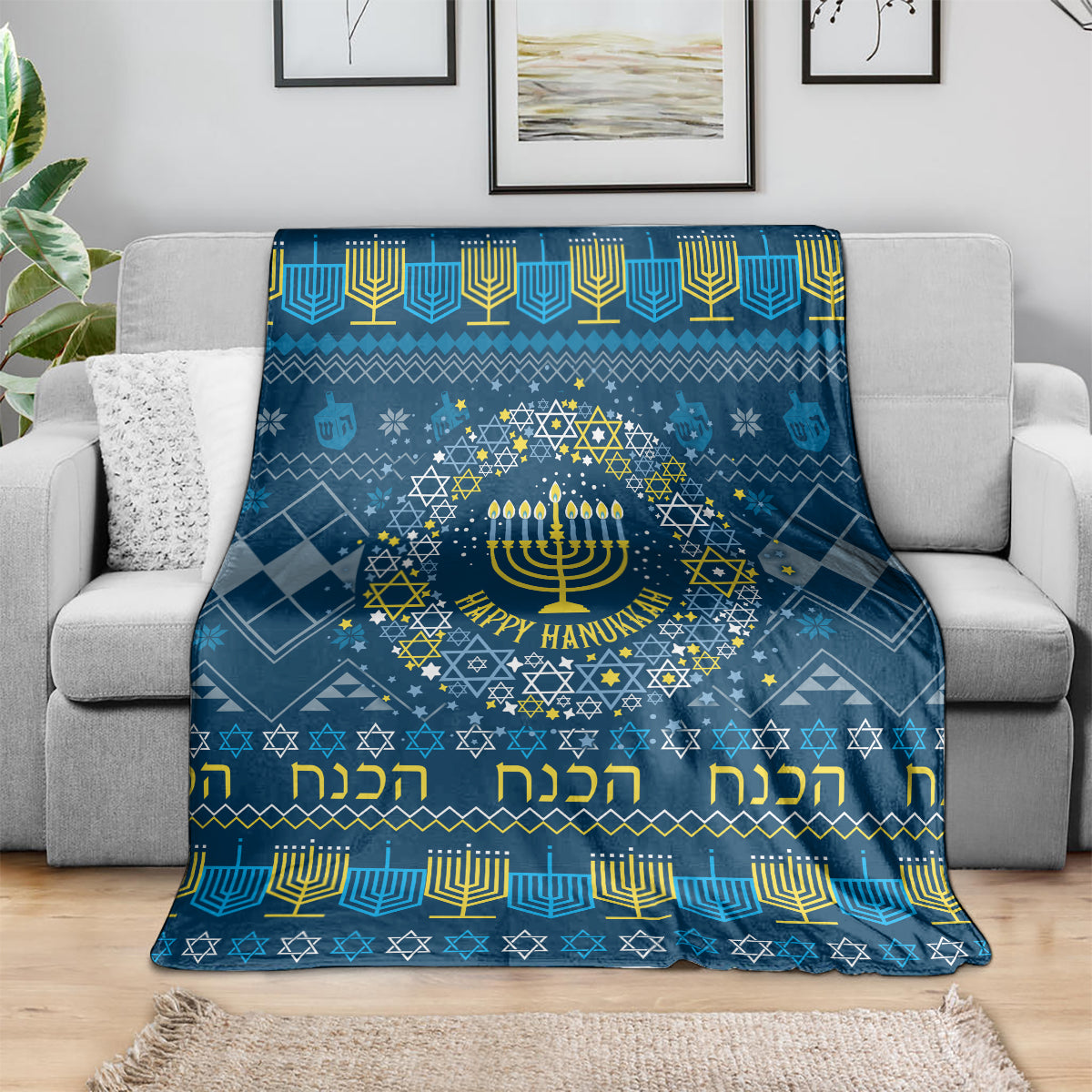 Blue Hanukkah throw blanket with menorah and geometric Star of David border on couch