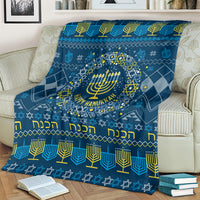 Blue Hanukkah blanket draped over sofa with menorah wreath and gold trim pattern