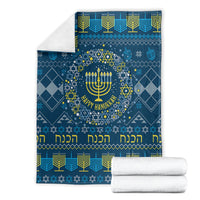 Folded blue Hanukkah blanket with menorah wreath, Star of David pattern, and gold trim
