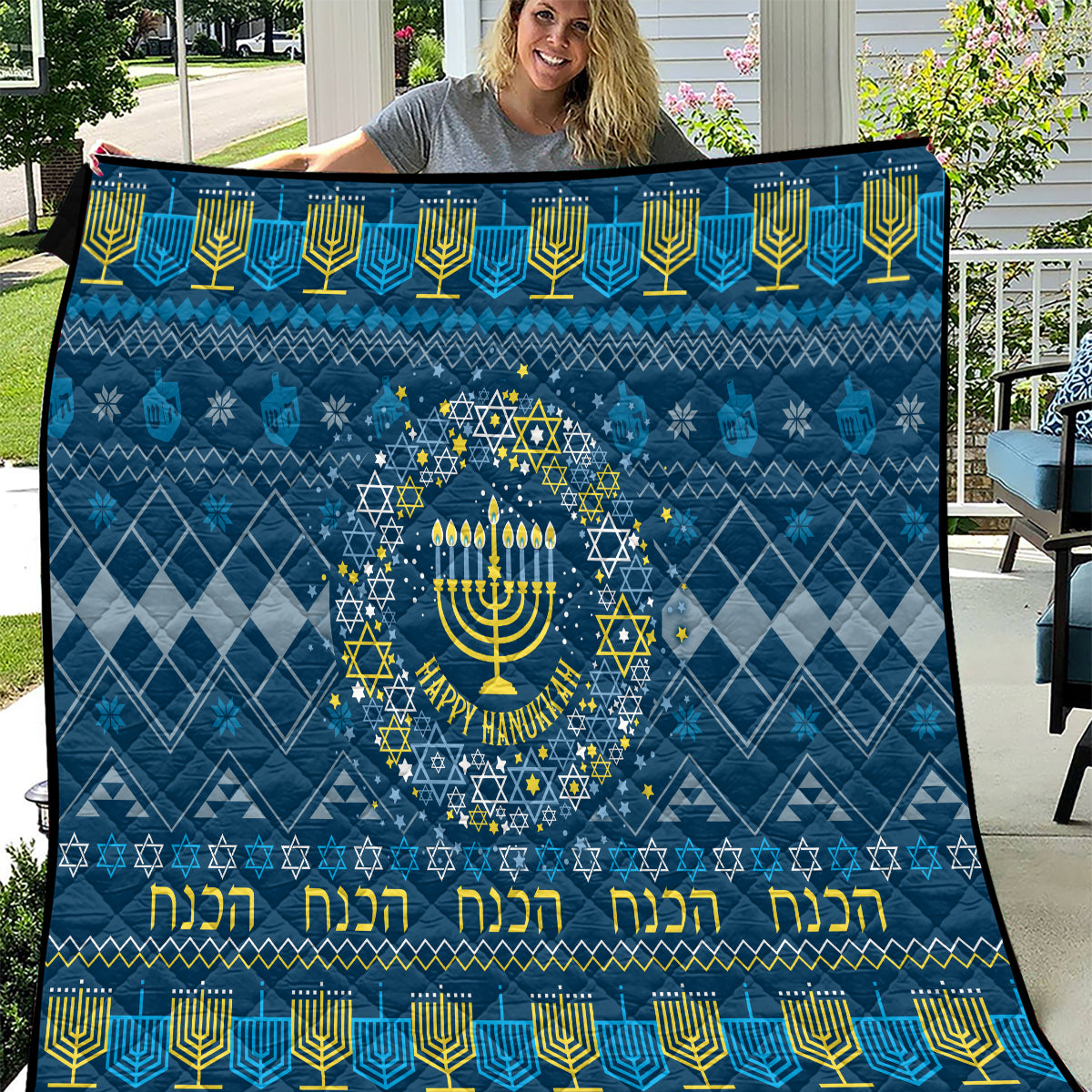 Blue Hanukkah quilt with central menorah in a star wreath and yellow decorative text