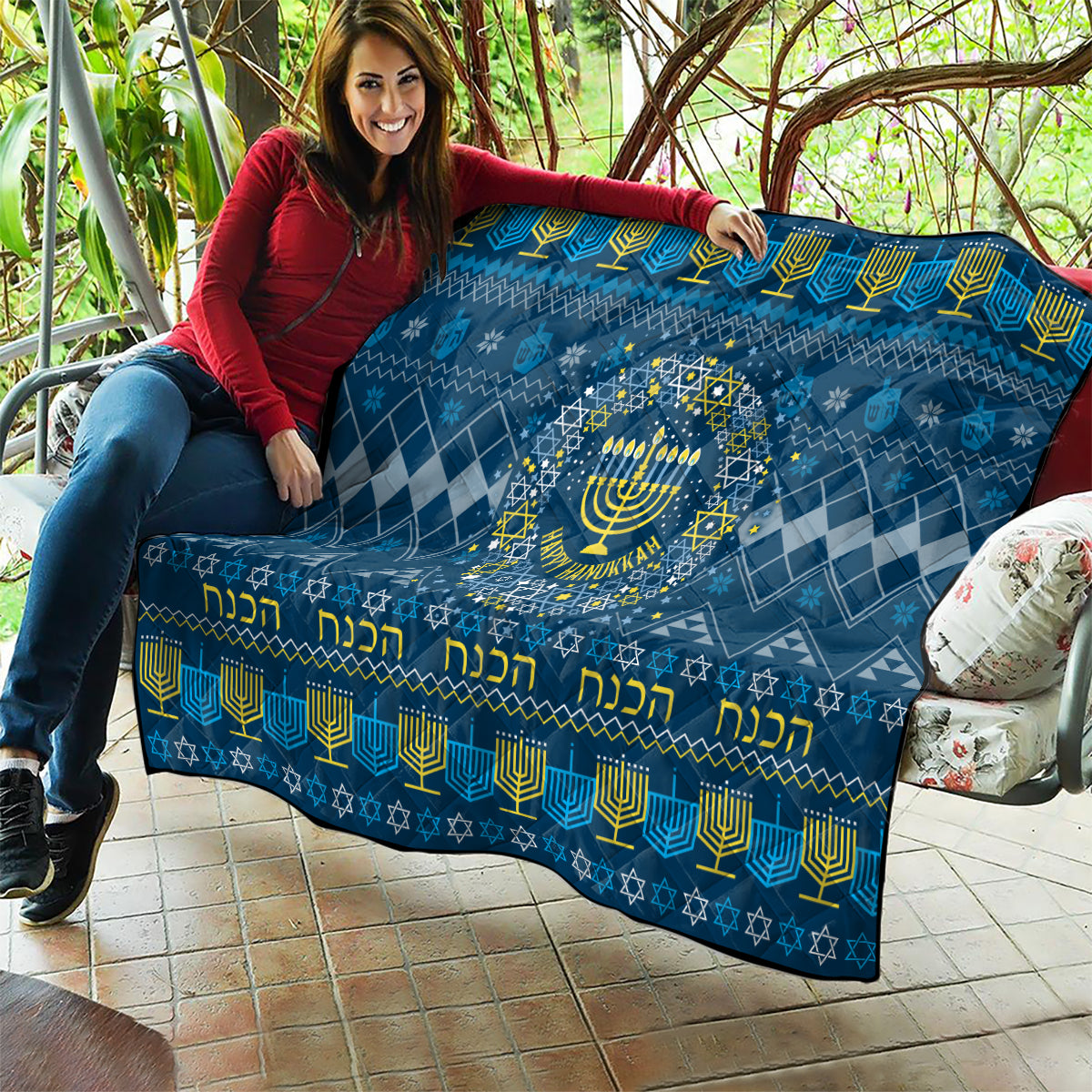 Blue Hanukkah quilt draped over couch with central menorah and diamond geometric pattern