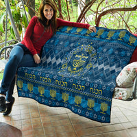 Blue Hanukkah quilt draped over couch with central menorah and diamond geometric pattern