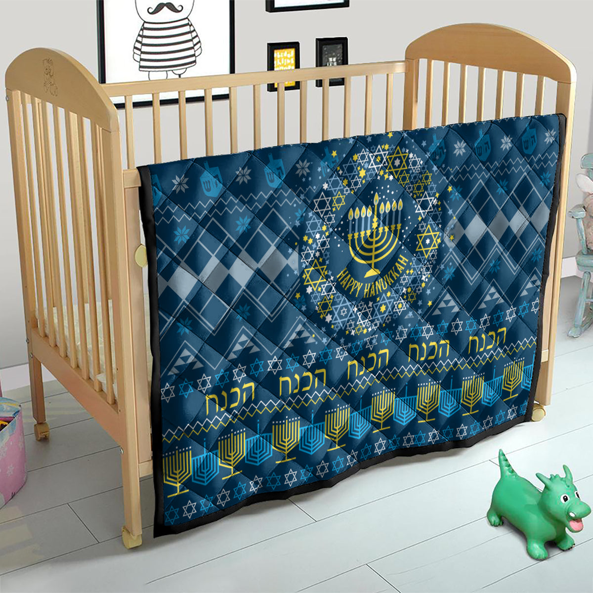 Blue Hanukkah quilt on crib with menorah star center and yellow Hebrew-style lettering