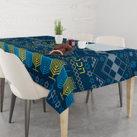 Blue Hanukkah tablecloth with menorah and star motifs on dining table