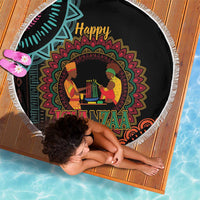 Round black Kwanzaa mandala beach blanket with white fringe, laid out on ground