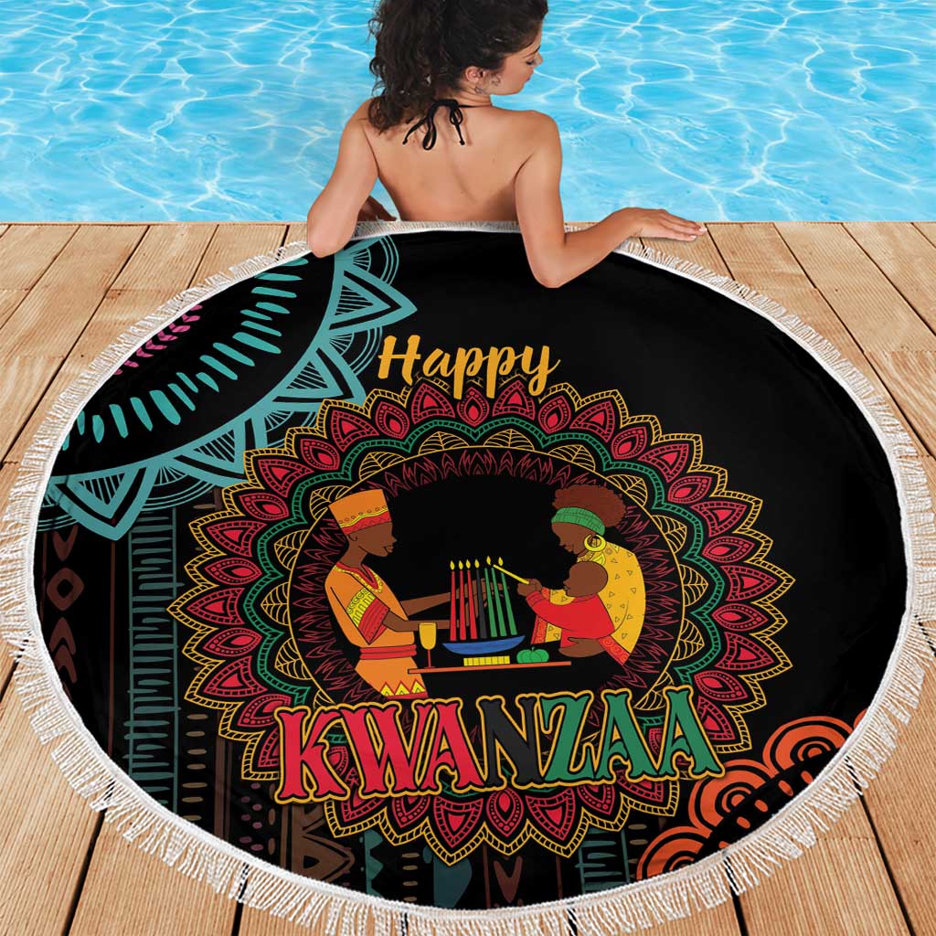 Round black Kwanzaa mandala beach blanket with white fringe, draped on deck by pool