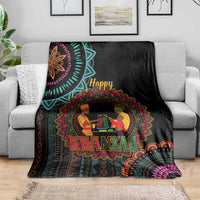 Black Kwanzaa mandala blanket with “Happy Kwanzaa” and figures, across gray couch