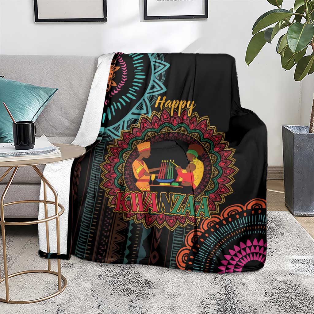 Black Kwanzaa mandala blanket with “Happy Kwanzaa” figures, draped over chair