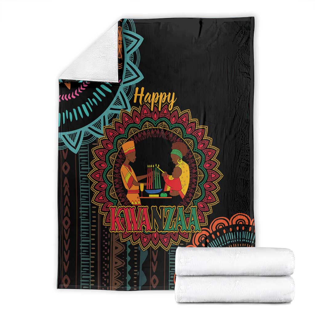Black Kwanzaa mandala blanket with “Happy Kwanzaa” design, folded with white towels