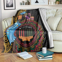 Black African tribal blanket with colorful Kwanzaa candles and figures, draped on sofa