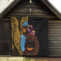 African quilt in barn doorway: black quilt with yellow patterned section and colorful Kwanzaa art
