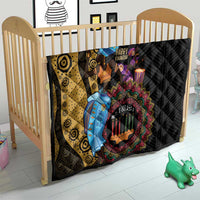 African quilt in crib: black and yellow swirl design with colorful Kwanzaa candle artwork
