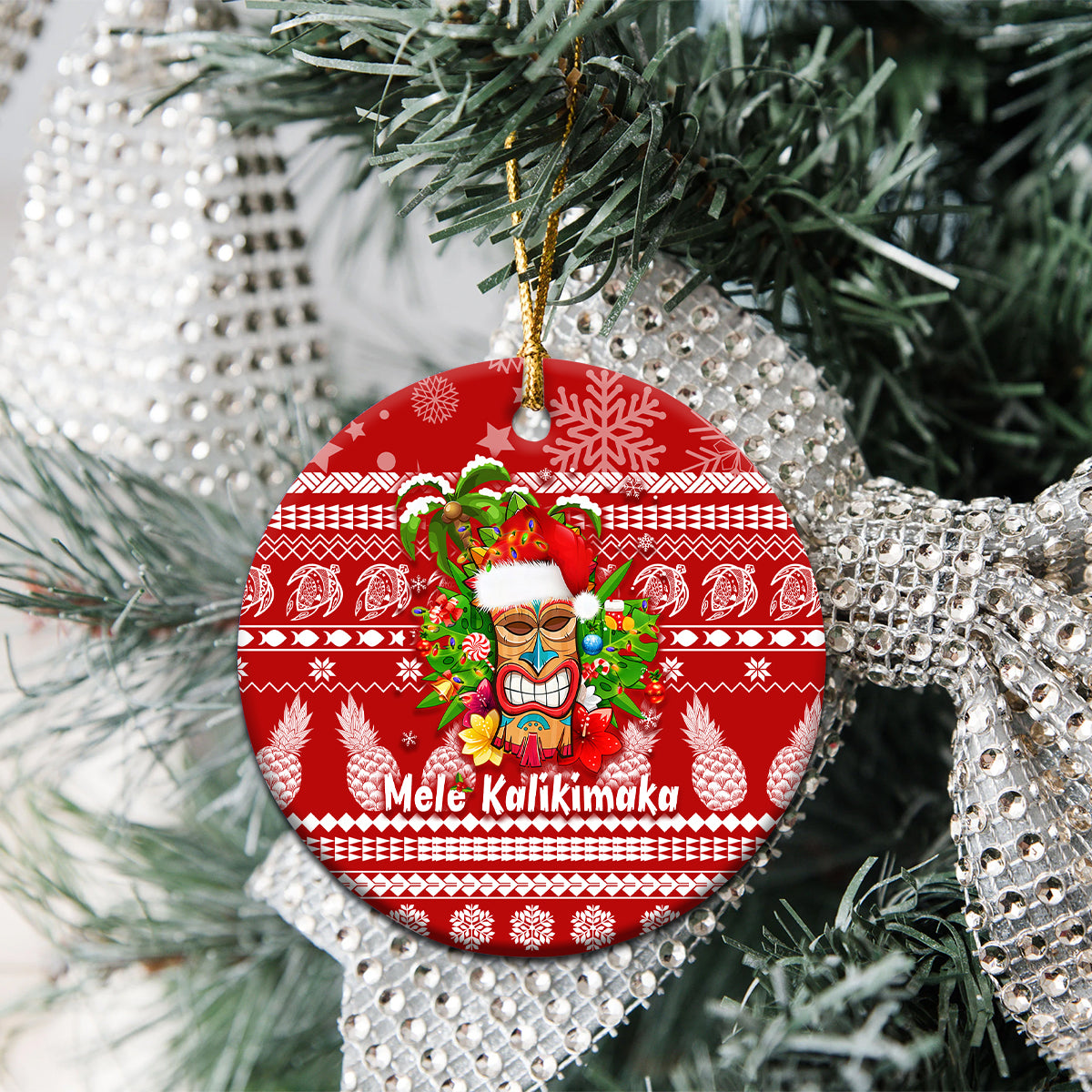 Red round ceramic Christmas ornament with Mele Kalikimaka tiki face and green garland