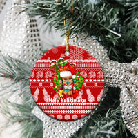 Red round ceramic Christmas ornament with Mele Kalikimaka tiki face and green garland