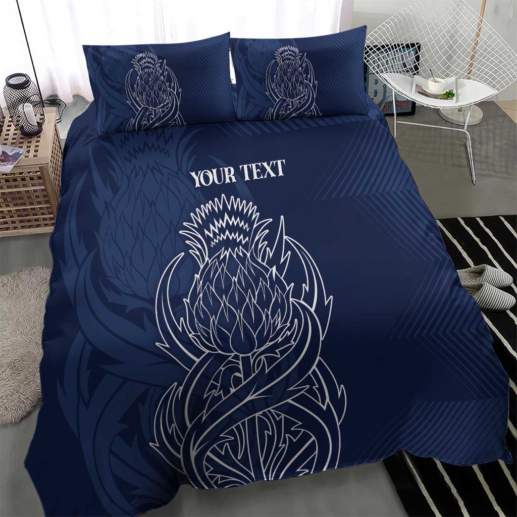 Blue personalized duvet cover with two pillows; white thistle-style line art and text