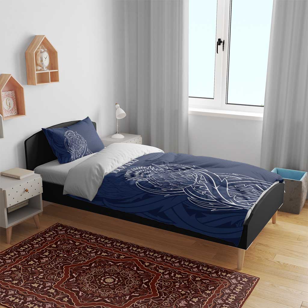Blue personalized duvet cover and two pillows with white thistle line art and text