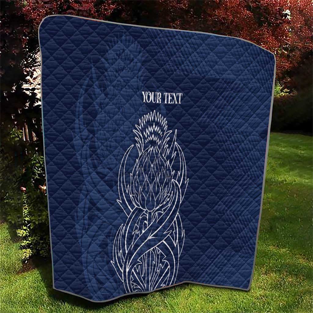 Blue quilt blanket with thistle line art and 'YOUR TEXT' angled