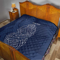 Blue quilt blanket with thistle line art and 'YOUR TEXT' over bed
