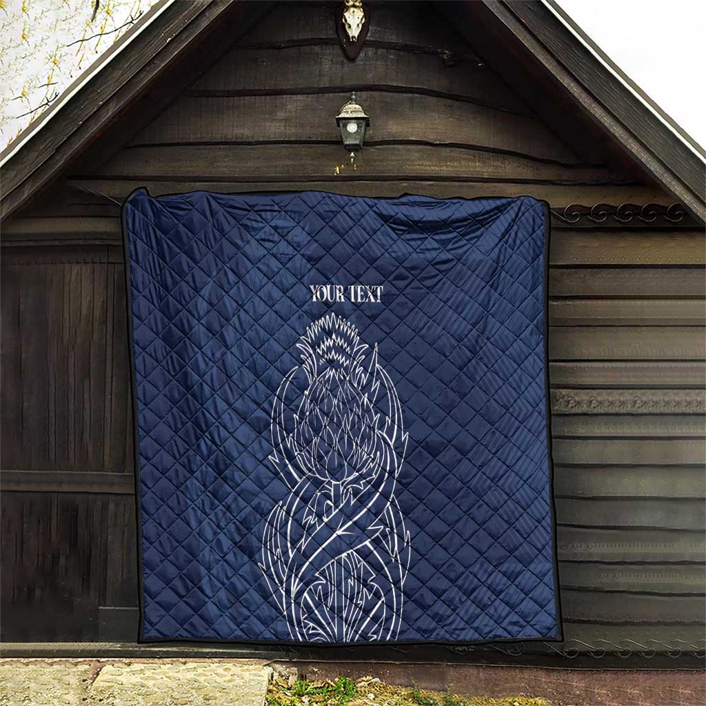 Blue quilt blanket with thistle line art and 'YOUR TEXT' hanging