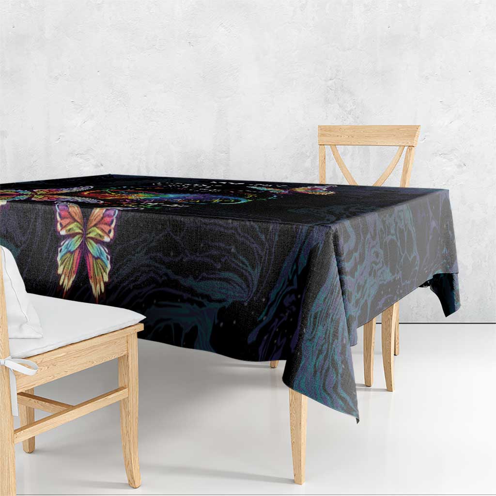 Dark navy tablecloth with a colorful butterfly on the corner, hanging over table edge