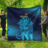 Large quilt blanket laid out outdoors in dark navy and blue stripes with lion artwork.