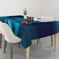 Navy and cyan patterned tablecloth on a dining table with plates and cups