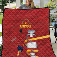 Red quilt with diamond quilting and Spain crest graphic, shown close-up outdoors