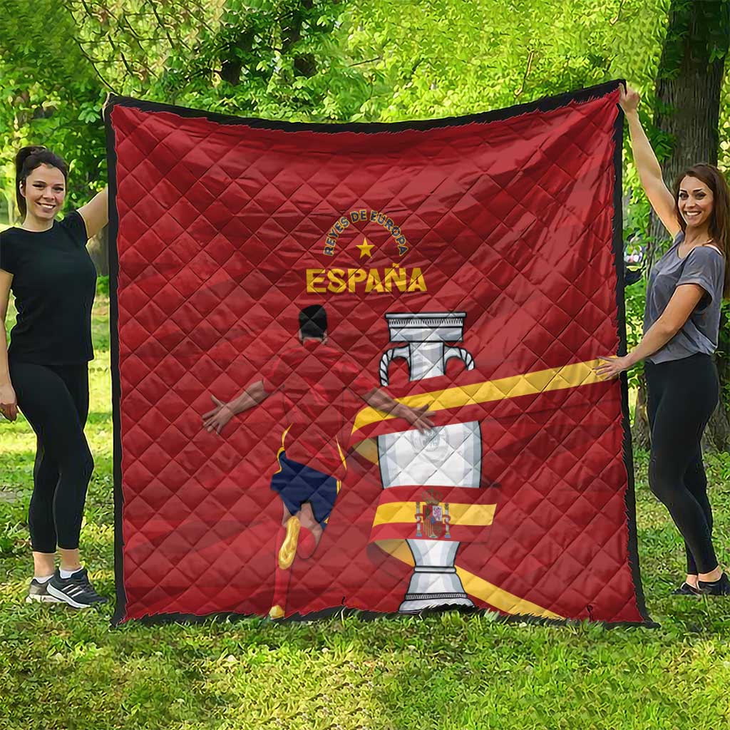 Red quilt with diamond quilting and Spain crest graphic, held up outdoors