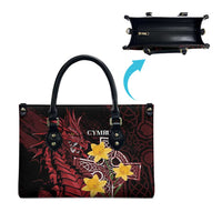 Red and black leather-look tote bag with yellow star emblem, side view with top handles