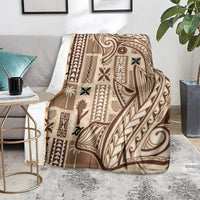 Beige tapa blanket with dark tribal pattern, draped over a chair