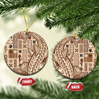 Round beige ceramic Samoa tapa ornament with dark patterned design and gold hanging loop.