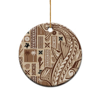 Round beige ceramic Samoa tapa ornament with dark patterned design and gold hanging loop.
