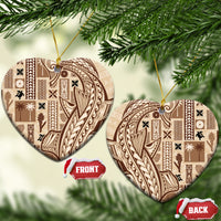 Beige heart-shaped ceramic tapa ornament with dark patterned design and gold hanging loop.