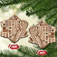 Pair of beige heart-shaped ceramic tapa ornaments with dark pattern and gold hanging loops.