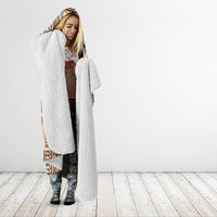 Beige hooded blanket with brown tapa pattern and long white fleece robe lining.