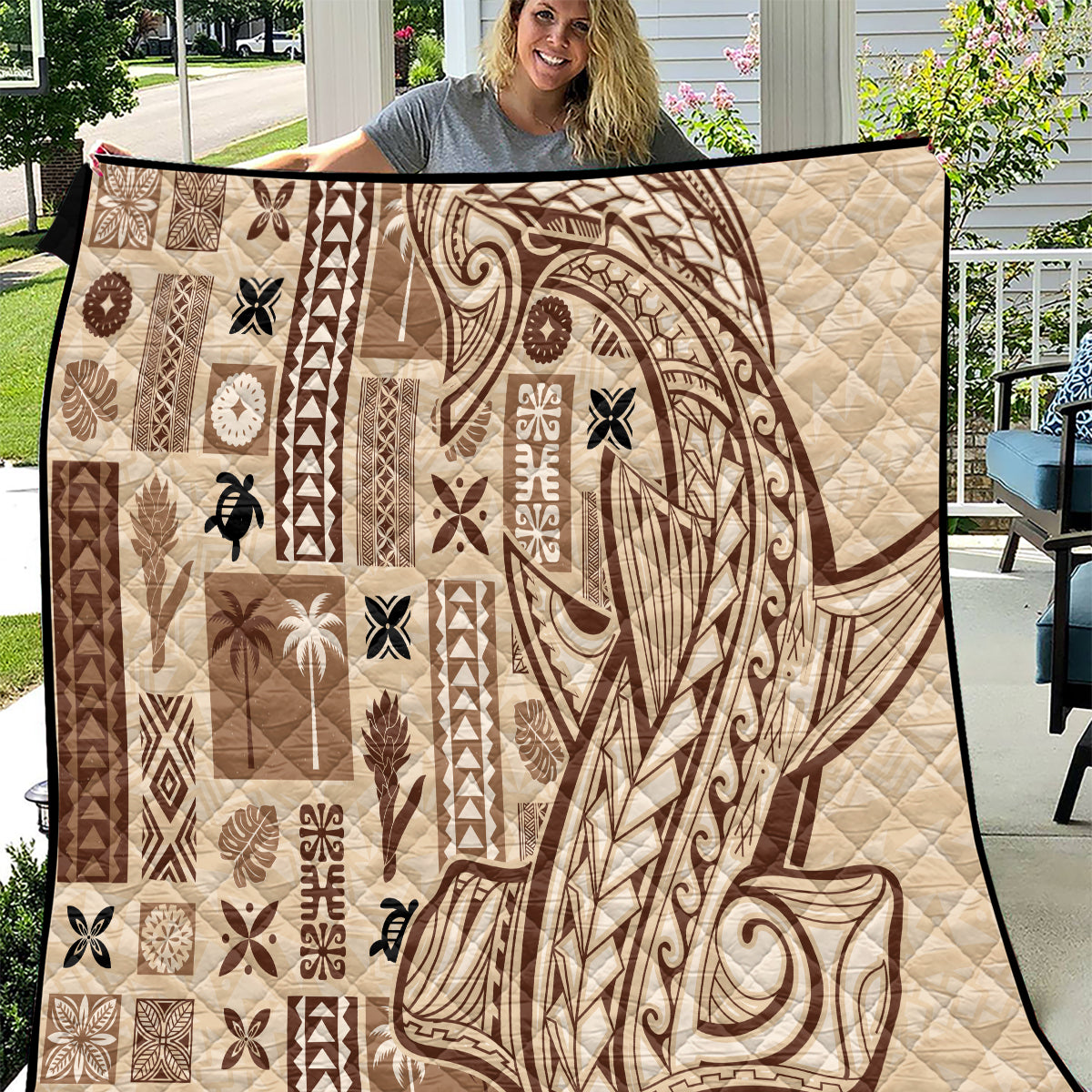 Beige quilt with tapa and tatau patchwork pattern in dark brown, quilted texture.