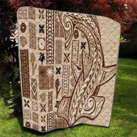 Beige tapa-pattern quilt with dark brown geometric blocks and swirling motifs, quilted.